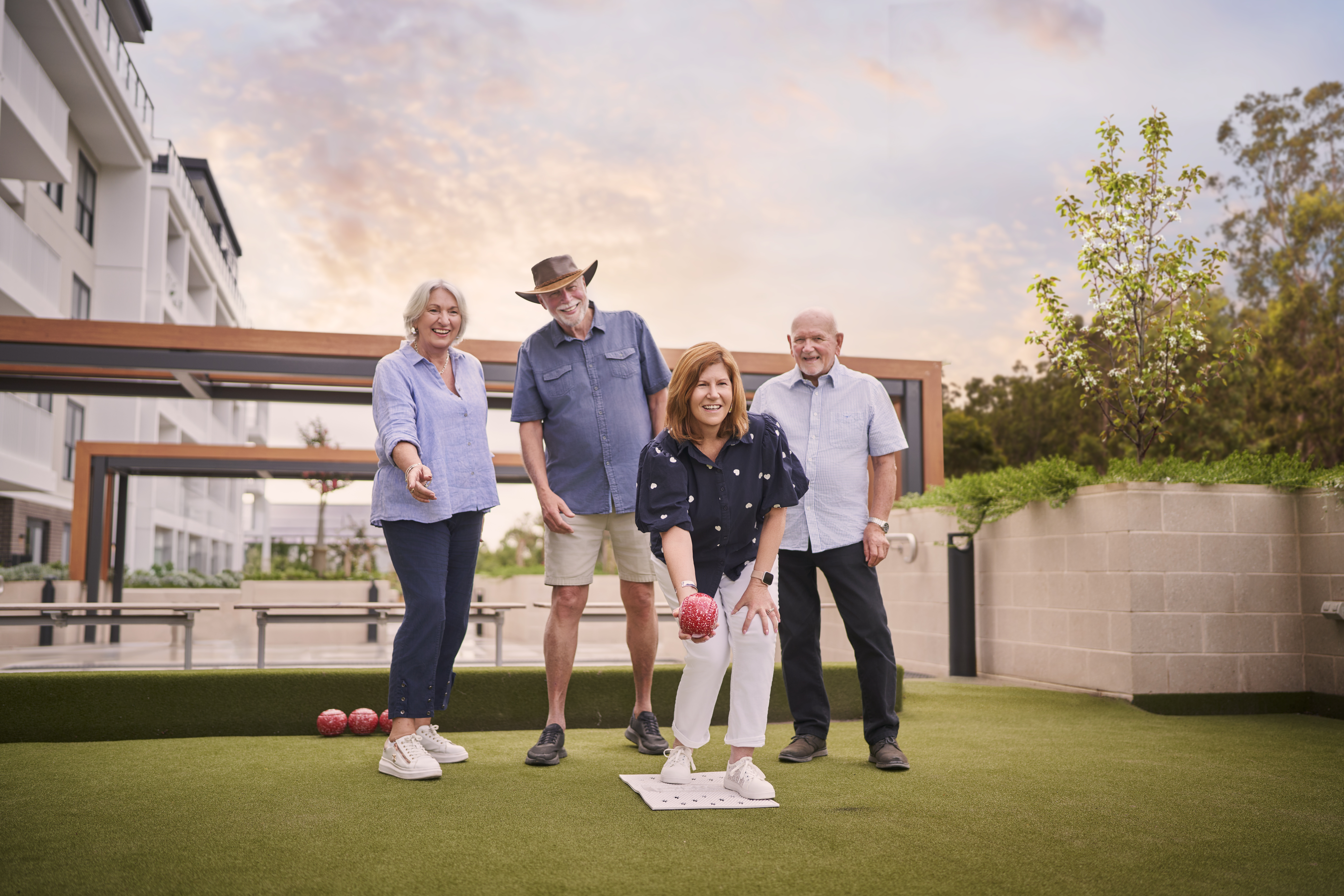 a group of older people playing lawn bowls