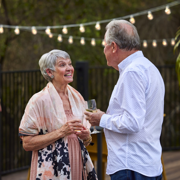 Older couple chatting in an outdoor entertainment setting