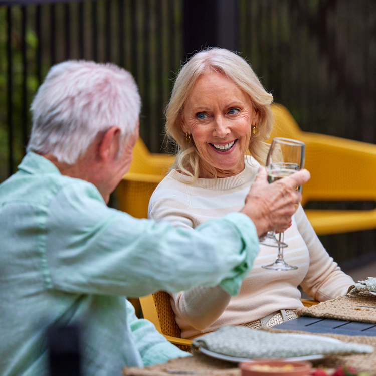 Older couple cheersing in an outdoor setting