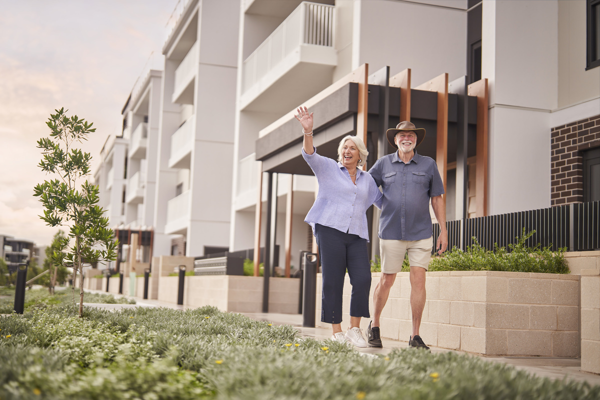a senior couple walking and waving at someone