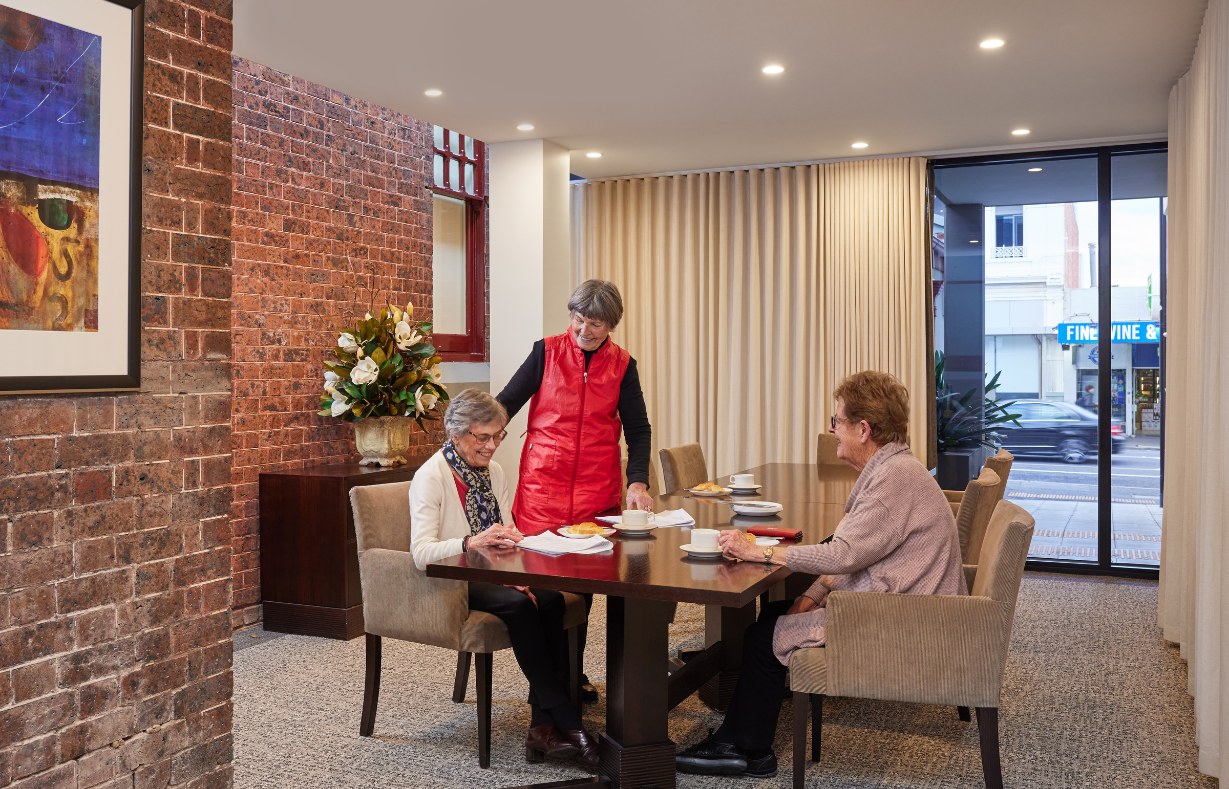 The Brighton on Bay women socialising over morning tea around dining table