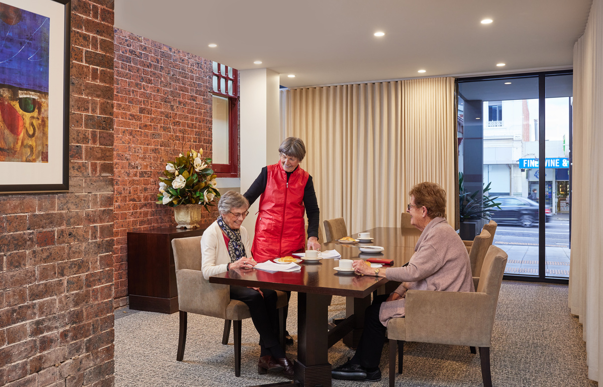 The Brighton on Bay women socialising over morning tea around dining table