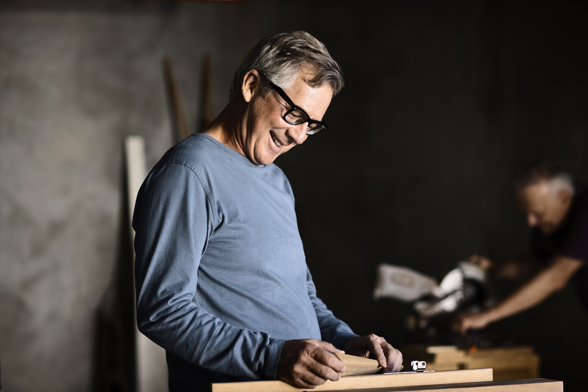 A male with glasses working in a wood workshop