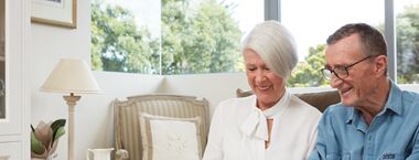 Rhonda and Terance sit in their bright modern apartment at The Baytree by Ardency.