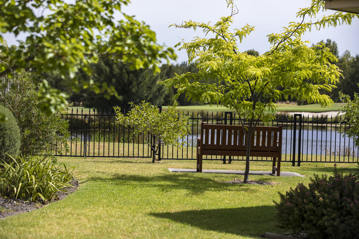 Waterford Park image of bench seat in gardens looking towards lake
