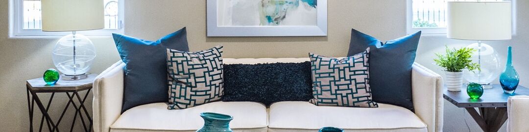 Updating your much-loved white couch with calming blue accent cushions is one way to start with interior styling for your new retirement home.