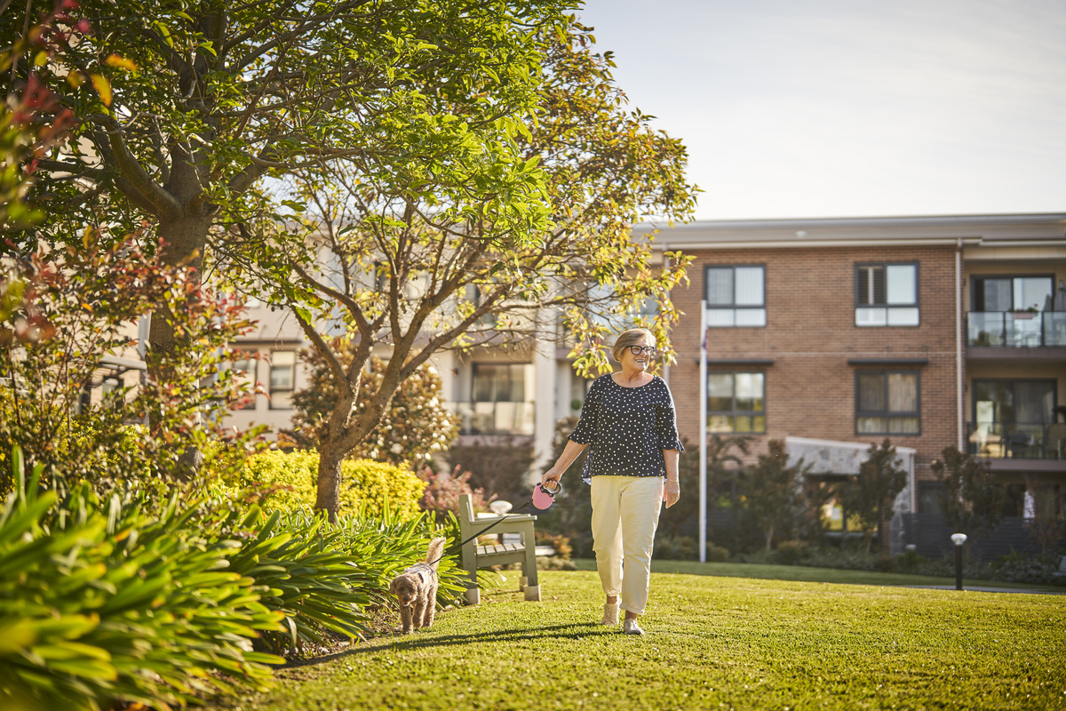 Nelsons Grove resident with pet dog walking in the gardens