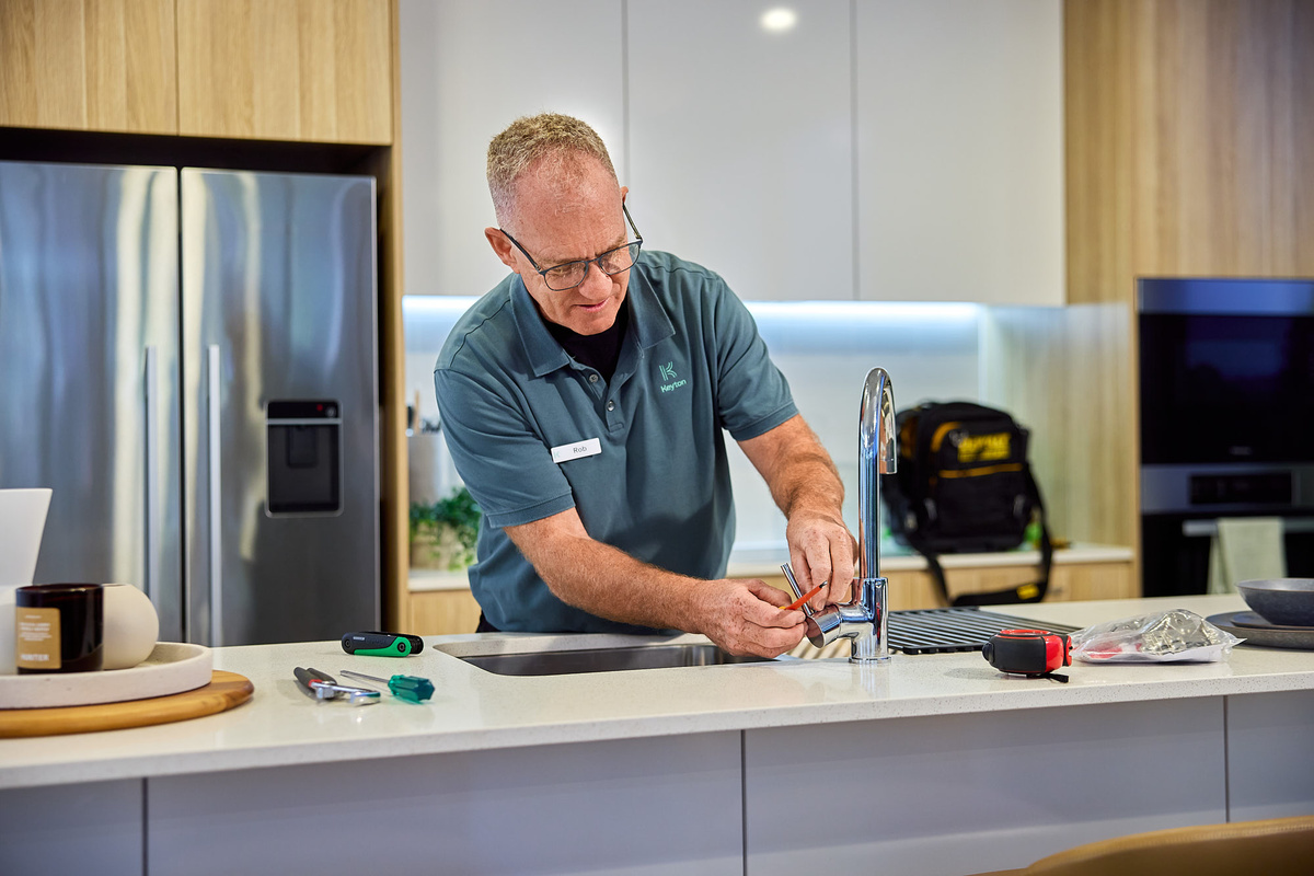 A plumber fixing the kitchen tap