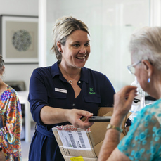 A female Keyton staff member holding a box for an elderly female resident