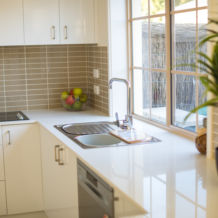 A clean and organised kitchen featuring neutral tones and minimal clutter 