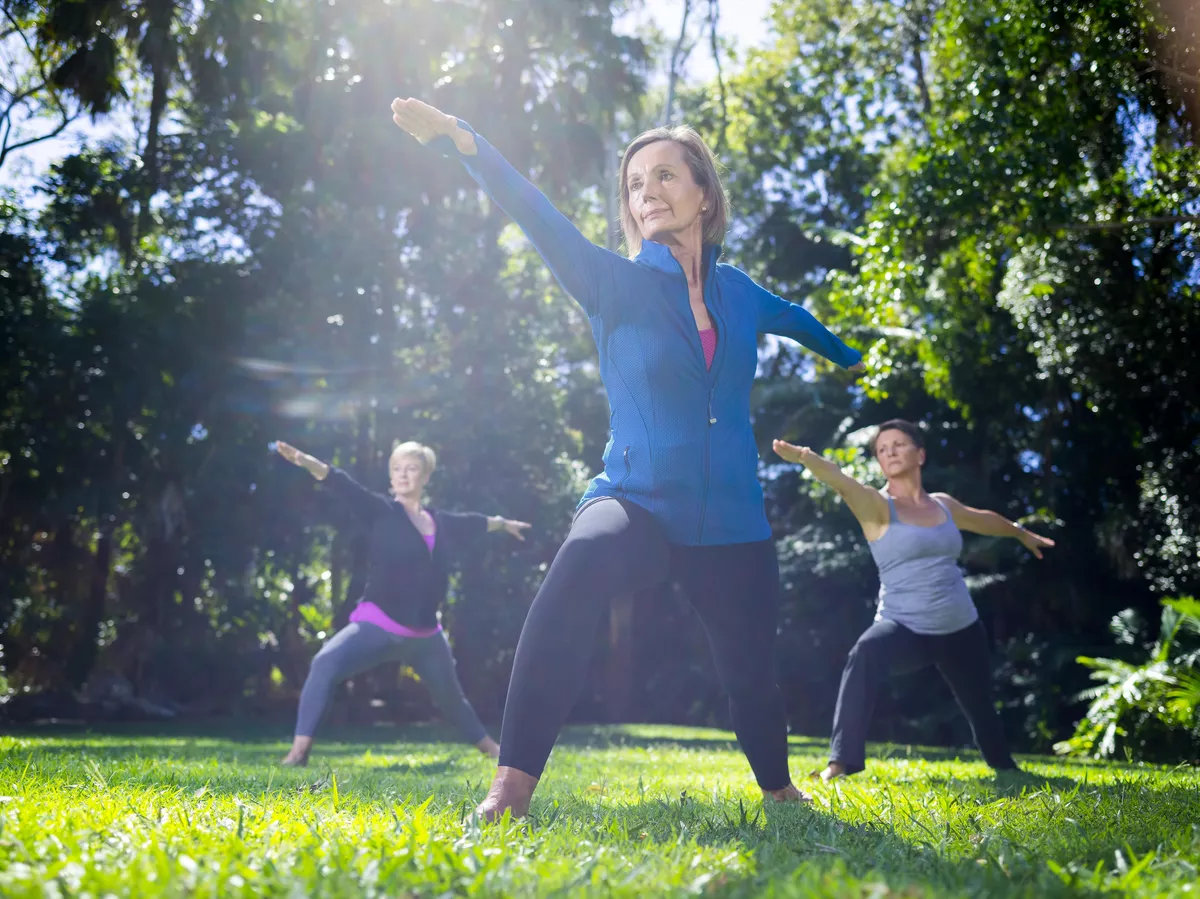 Three women doing yoga in a park