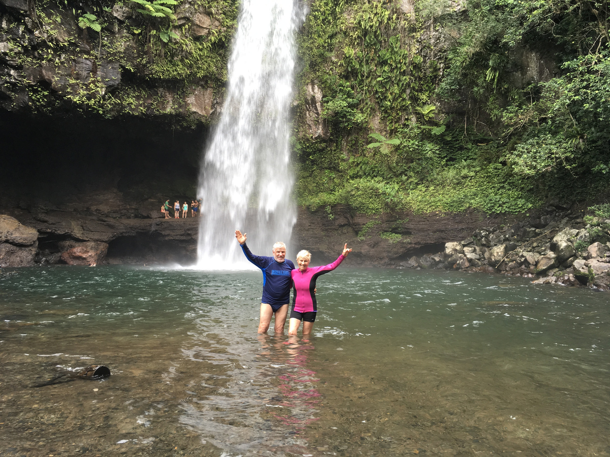 Joan and Russell posing in front of a waterfall