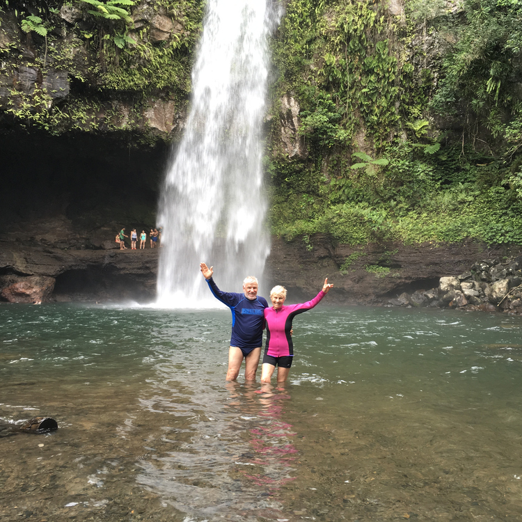 A couple posing in a plunge pool on one of their travels