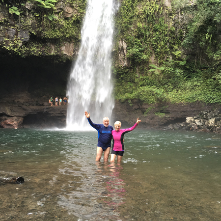 A couple posing in a plunge pool on one of their travels