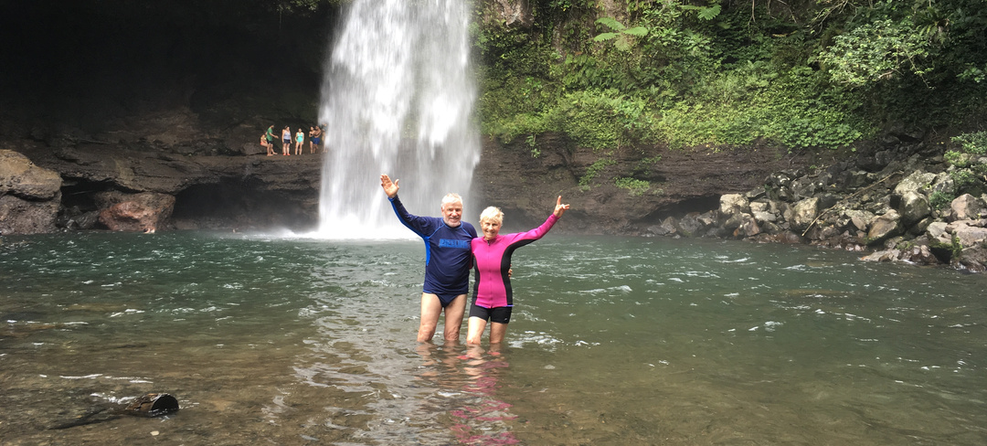 A couple posing in a plunge pool on one of their travels