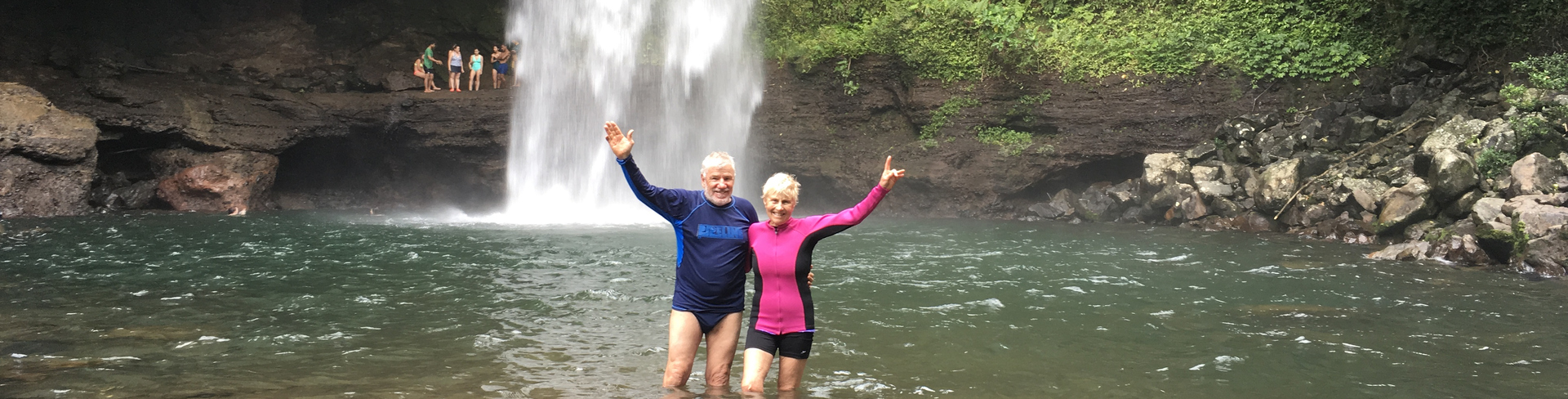 A couple posing in a plunge pool on one of their travels