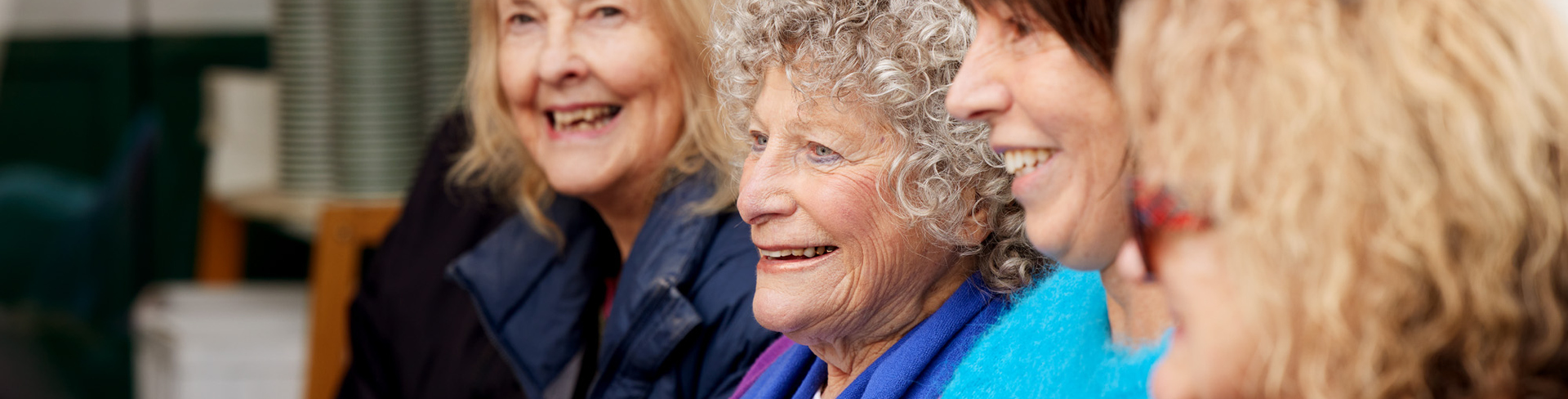 A group of women sitting next to each other and smiling