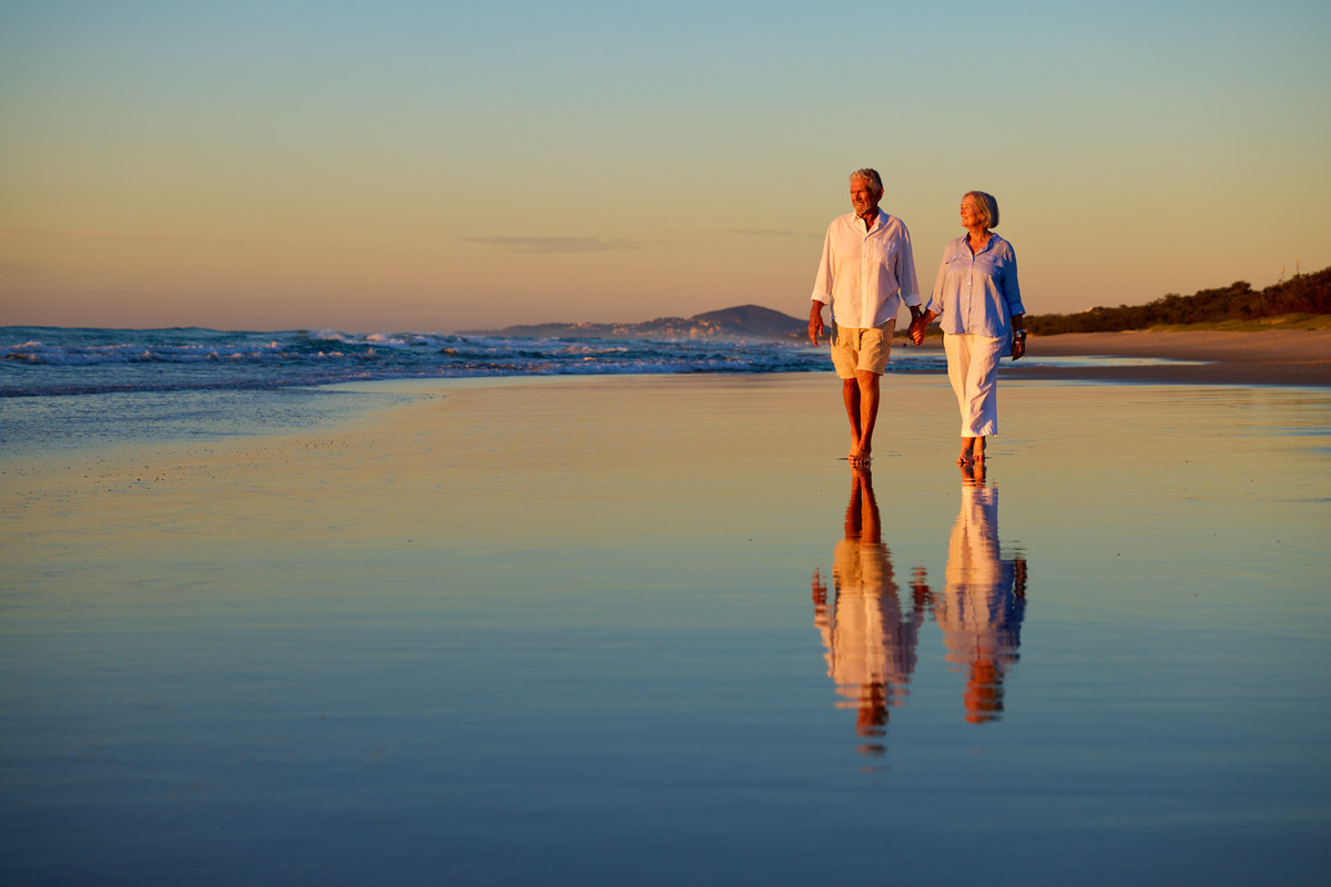Couple walking along Sunrise Beach at the Sunshine Coast