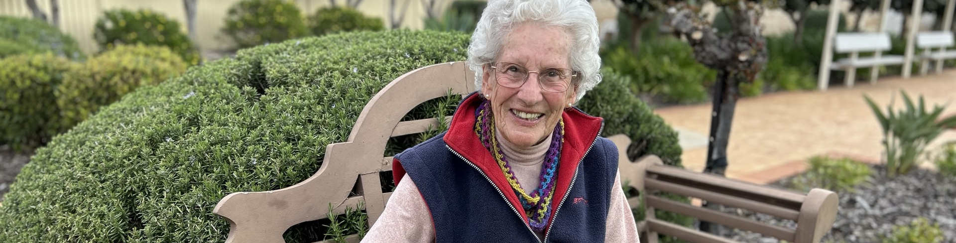 The Pines resident Daisy Fleming sitting on a bench in smiling to the camera
