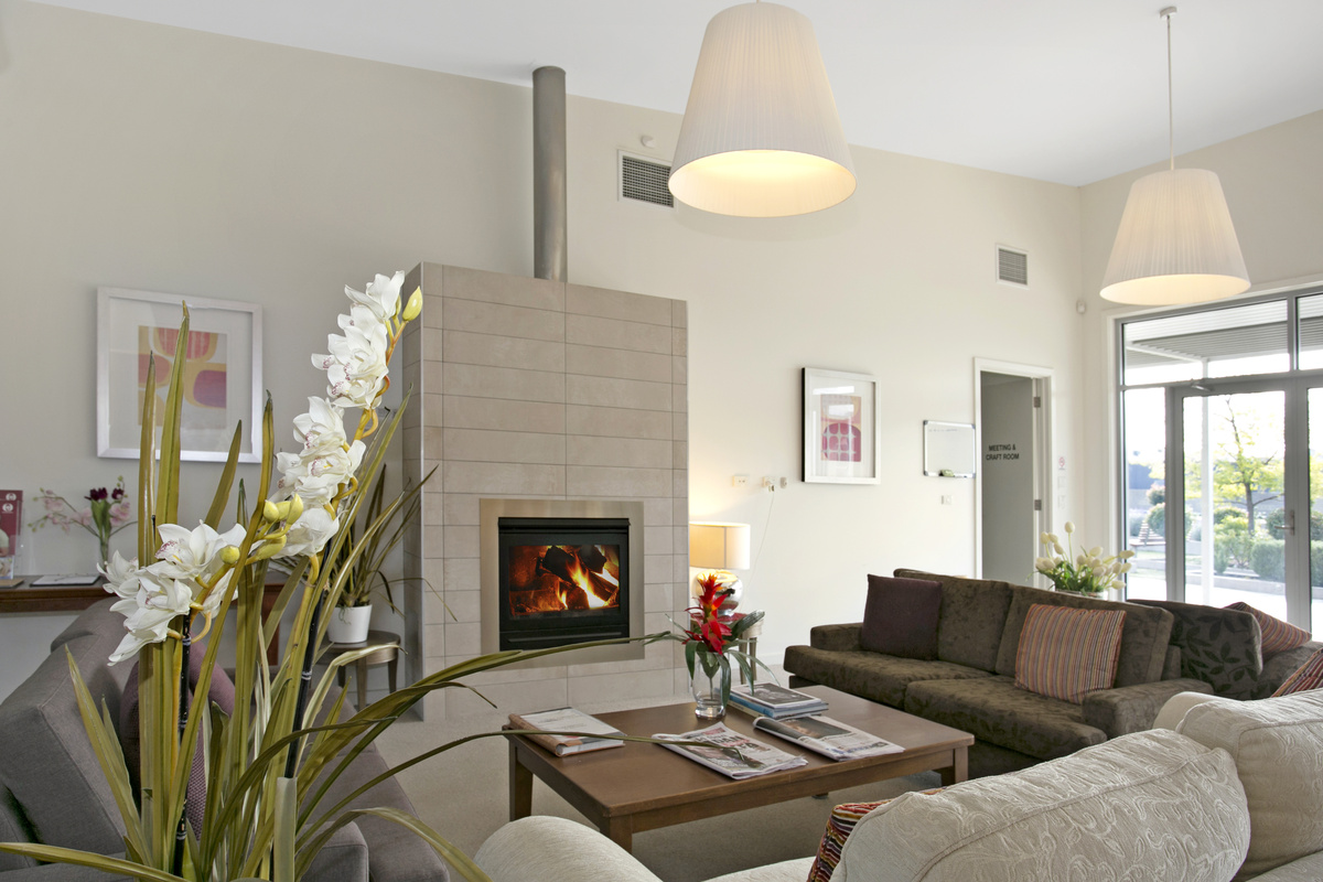 Caesia Gardens spacious lounge area with seating, fireplace and books