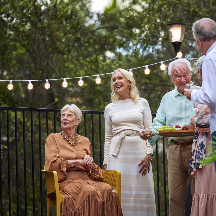 A group of retirement village residents socialising together at happy hour.