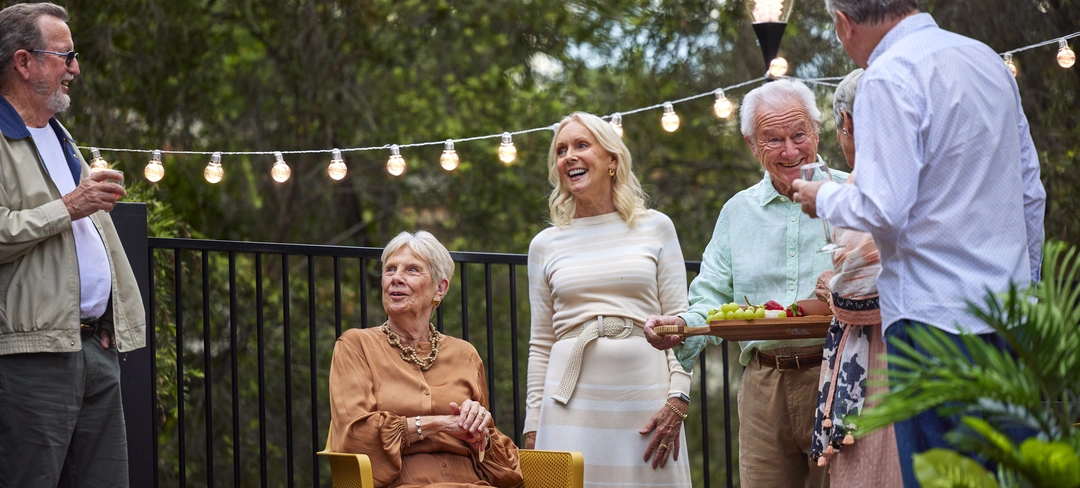 A group of retirement village residents socialising together at happy hour.