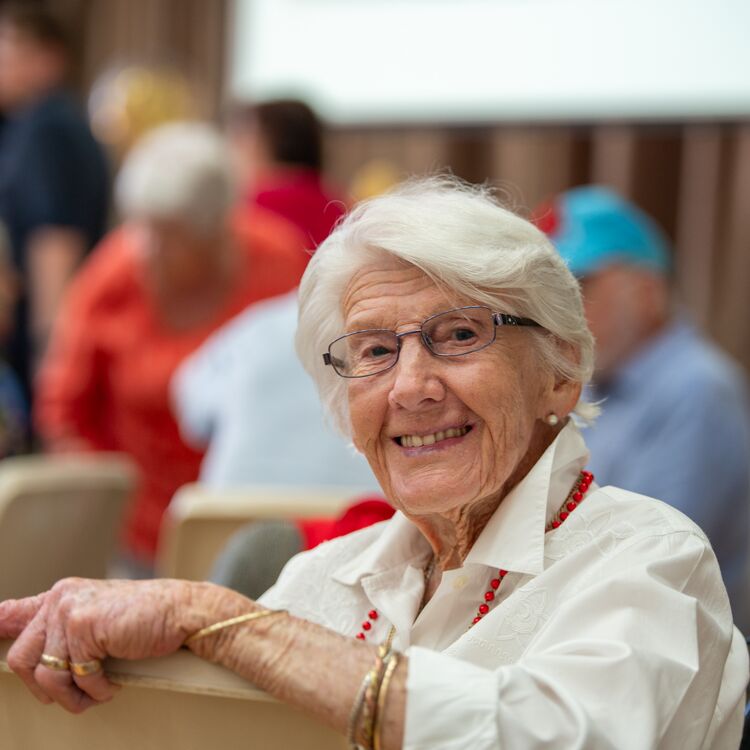 A senior citizen smiling at the camera 