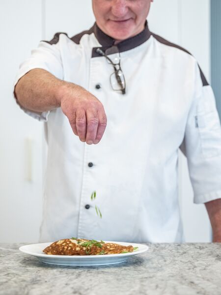 Ardency Aroona head chef Colin sprinkling garnish on a delicious meal