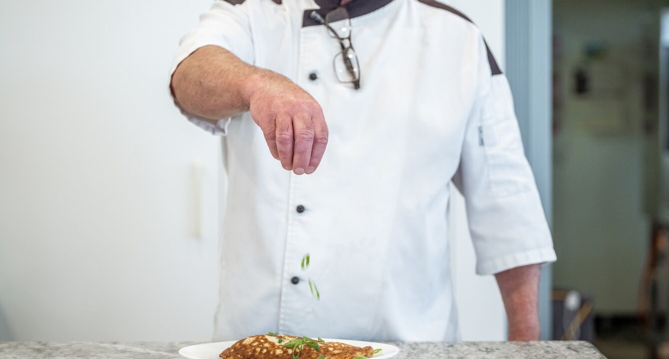 Ardency Aroona head chef Colin sprinkling garnish on a delicious meal