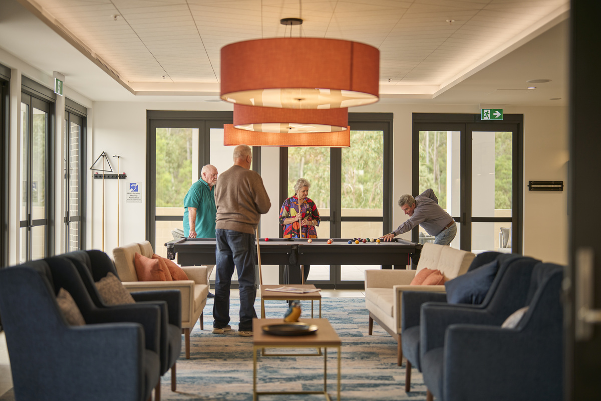 Kingfisher Grove Village Residents playing pool in bar lounge in clubhouse