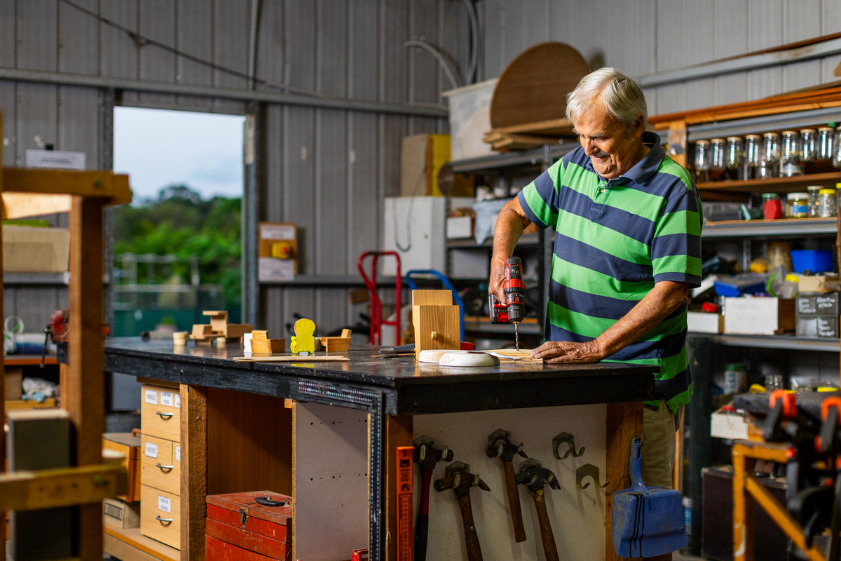 A male retiree working in a tool shed 