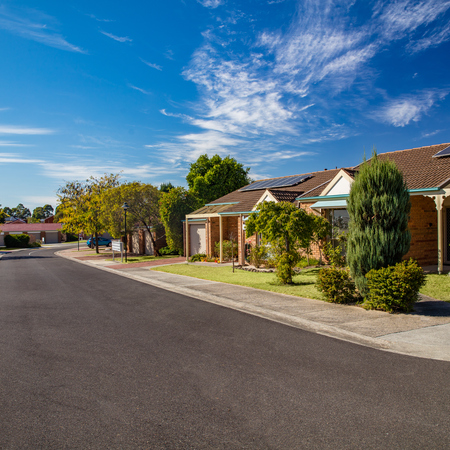 Peppertree Hill village roadway lined with homes, trees, lawns and lovely gardens