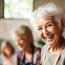 An elderly lady laughing to the camera at an event