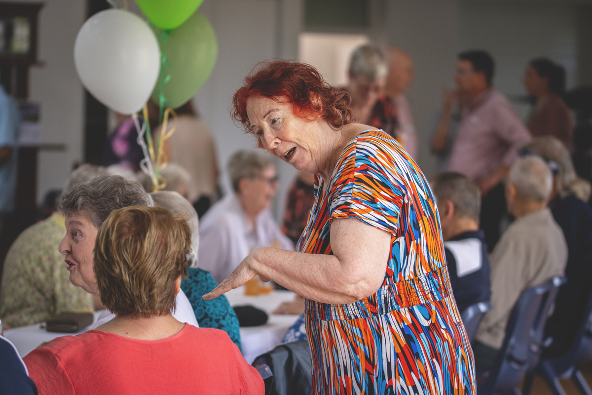 Residents of The Gardens on Linfield  seated together at the community centre reopening event.