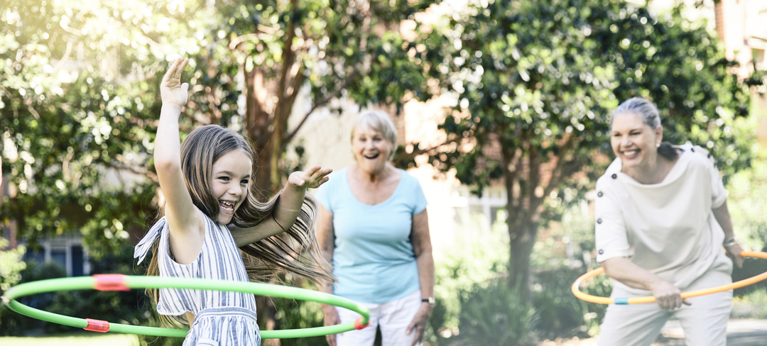 Family having fun playing hula hoop with granddaughter