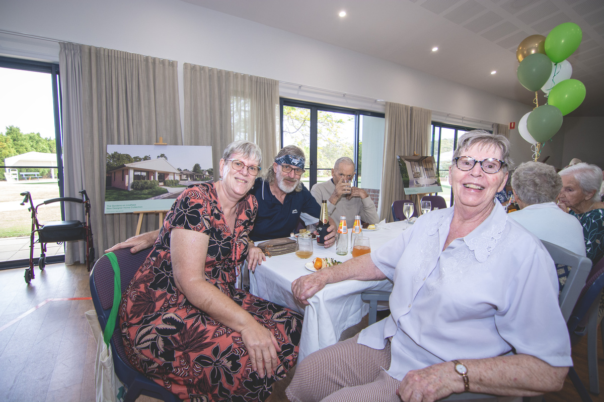 Residents of The Gardens on Linfield  seated together at the community centre reopening event.