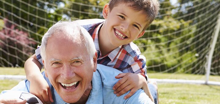 A smiling grandfather and grandson spending time playing and laughing and enjoying the bonds between grandparents and grandchildren.