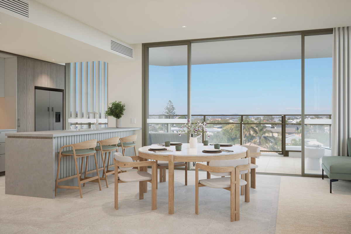 An open-plan dining and kitchen area of an apartment overlooking the view outside 