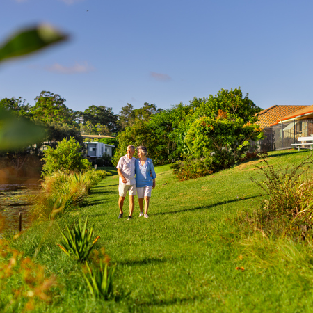 A retired couple walking along gardens at Allora Gardens retirement village