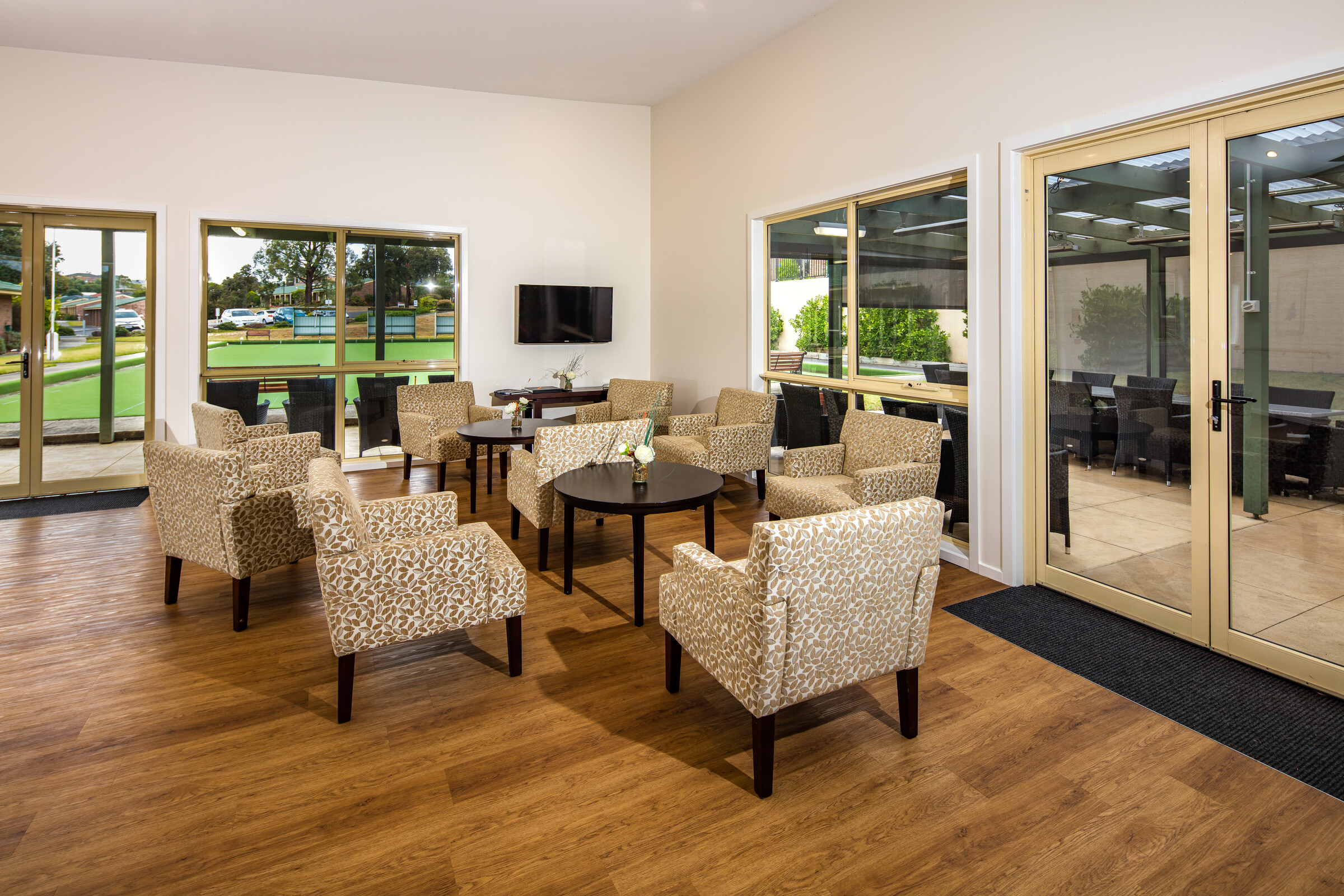 Meadowvale Village lounge area with seating with window outlook to bowling green and outdoor terrace