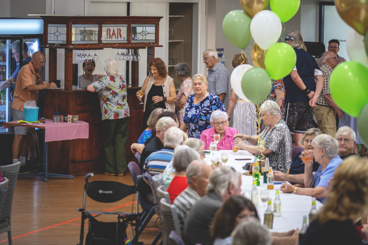 Residents of The Gardens on Linfield  seated together at the community centre reopening event.