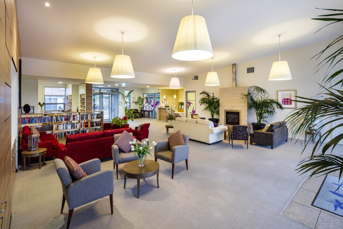 Caesia Gardens spacious lounge area with seating, fireplace and books