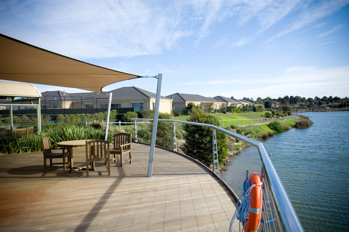 Waterford Valley Lakes covered terrace with seating beside lake and looking towards homes
