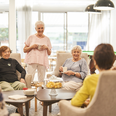 A group of residents at little Bay Apartments sitting around the table.having tea and chatting with each other happily.