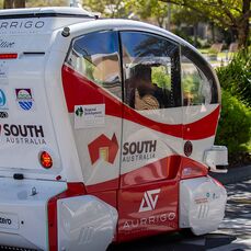 A red and white futuristic-looking driverless mobility vehicle at Elliot Gardens retirement village. 