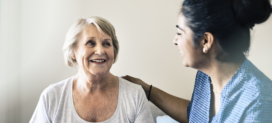 Female resident with nurse or carer smiling at each other