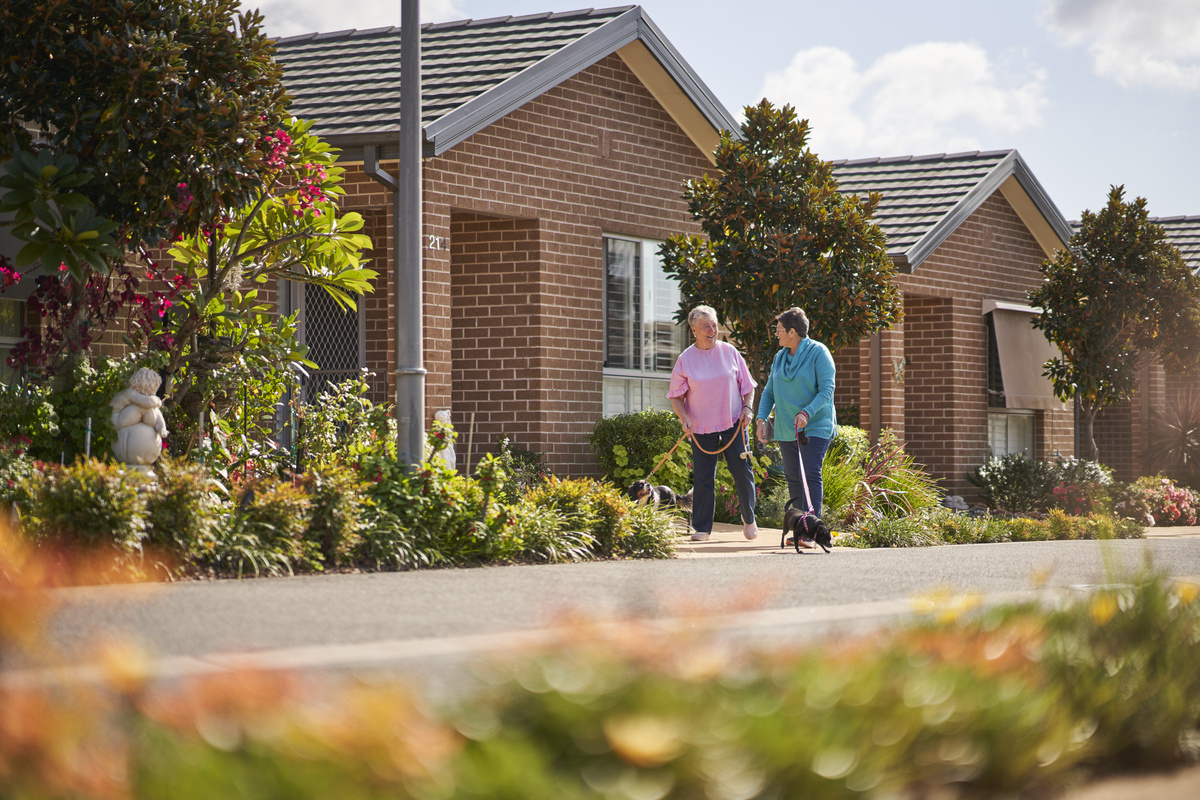 Two ladies walking their dogs at Rochford Place Village