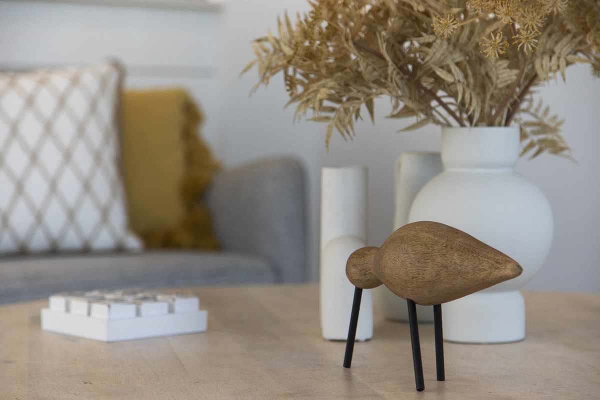  A close-up of the main living room table, styled with decorative knick-knacks small ornaments and vases
