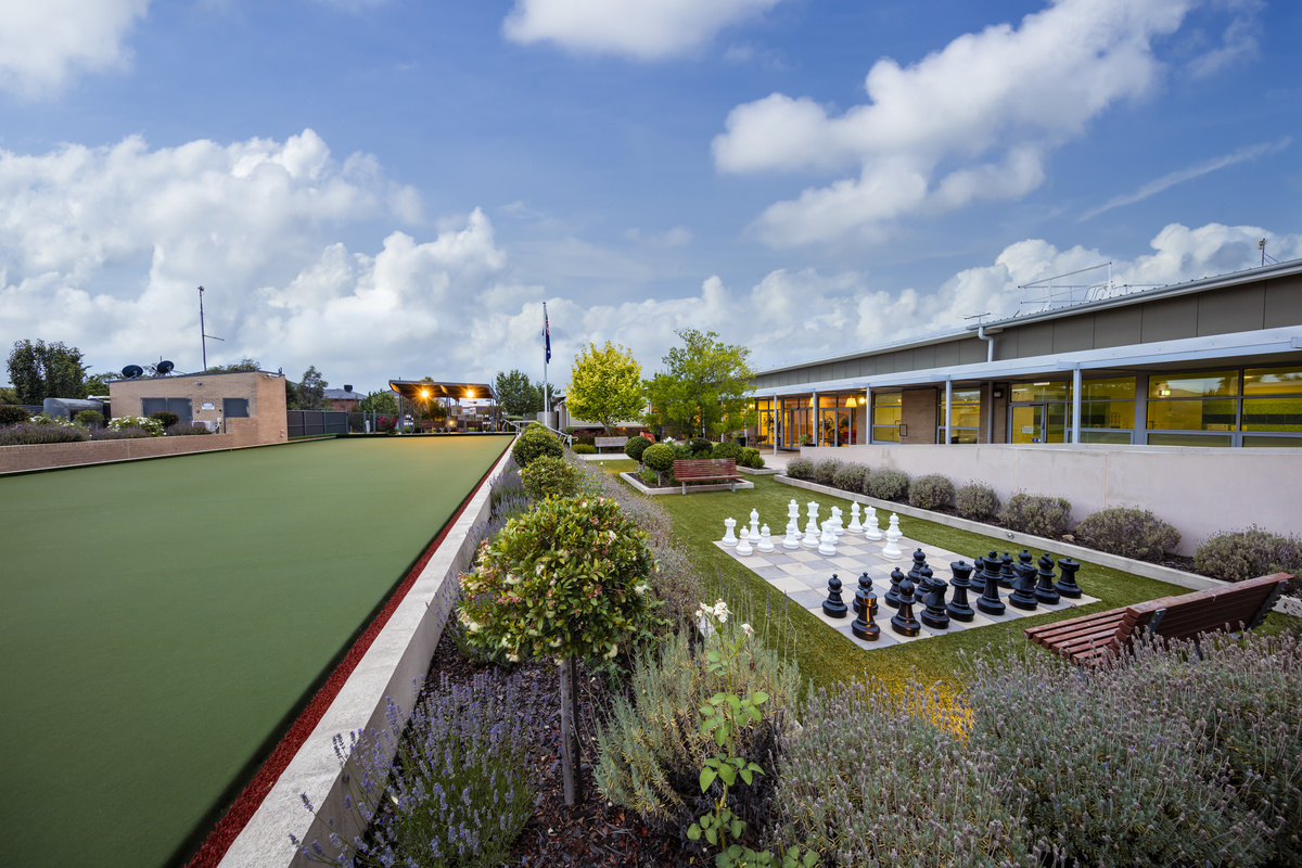 Caesia Gardens landscaping beside building with outdoor chess, bowling green, terrace and bench seat