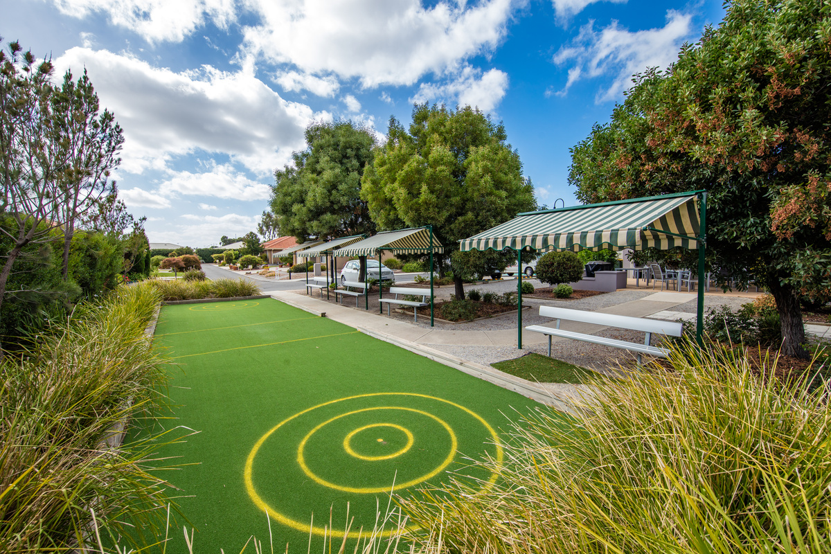 Windsor Park bocce court with seating and shade in garden area